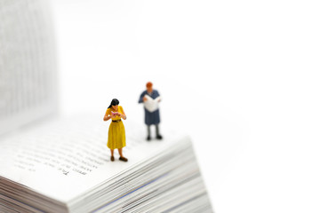 Miniature people : reading a book and Dictionary using for concept of Dictionary Day.