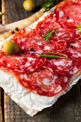 Chorizo sausage and salami, thin cut. spanish salami on the wood background with spices, paprika, pepper. Spicy food. Chili.