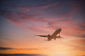 Fototapeta na wymiar Silhouette of plane fly on sky during sunset.