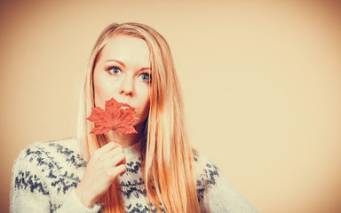 Woman holding orange autumn leaf