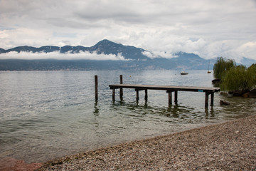 Landscape of lake Garda with a wooden pier
