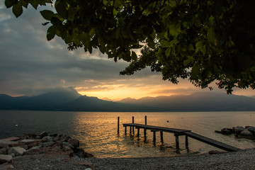Fototapeta na wymiar Landscape of Lake Garda, Italy with pier during beautiful summer sunset