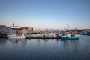 Fototapeta na wymiar Fishing boats at quay in fishing harbor in Bronnoysund Northern Norway
