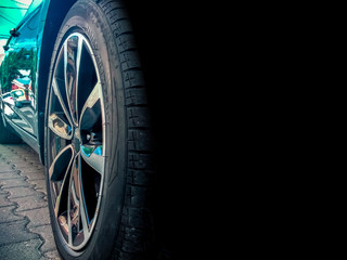 Fototapeta na wymiar Modern car wheel background with reflection of a residence and space for text