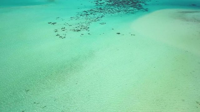 Aerial footage from a drone of blue lagoon and Motu Ahuna at Bora Bora island, Tahiti, French Polynesia, South Pacific Ocean (Bora Bora Aerial)
