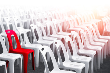 difference red color chair around with many white chairs for unique outstanding person concept