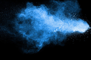 Blue purple dust explosion on black background. Freeze motion of color powder splashing.