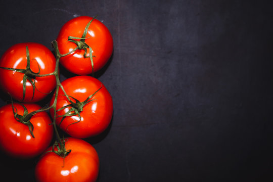 Ripe tomatoes on a dark background,