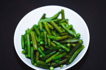 Cooked green beans on black background. Close up