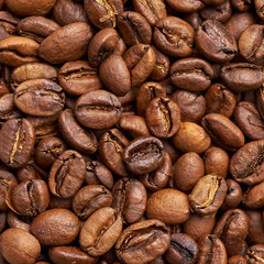 Beautiful light brown coffee beans. Ideal coffee texture for any layout. Top view on grains, macro shot, close-up. The basis for a hot aromatic drink.