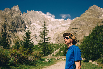 tourist wearing hat and sunglasses ,on european alps background