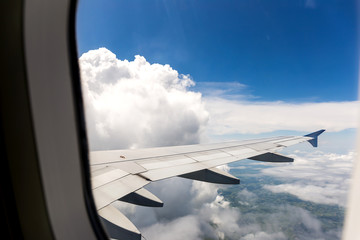Looking through window aircraft during flight in wing with a blue sky