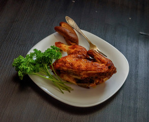 fried chicken on a white plate on a dark wooden background