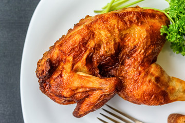 fried chicken on a white plate on a dark wooden background