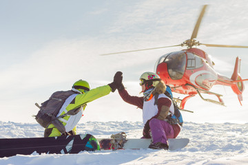 pair of freeriders of snowboarders give five when the helicopter lands © Baikal360