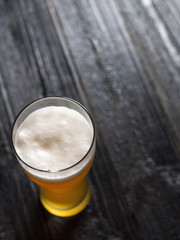 Light unfiltered wheat beer in a glass on a black table with copy space