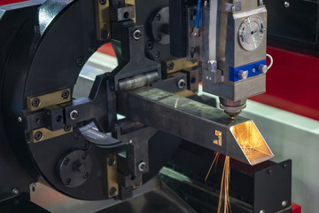 The CNC laser cutting machine cutting the hole at the  stainless  pipe or tube.The hi-technology manufacturing process.