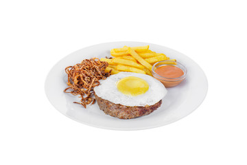 Cutlet, beef steak, lamb with scrambled eggs, french fries, fried onion and orange sauce on a plate, isolated white background. Side view. Serving for a cafe, a restaurant in the menu
