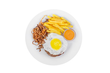Cutlet, beef steak, lamb with scrambled eggs, french fries, fried onion and orange sauce on a plate, isolated white background, view from above. Serving for a cafe, a restaurant in the menu