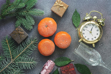 Fototapeta na wymiar Christmas background, tangerines, gifts, champagne, alarm clock are covered with snow. Top view,flat lay