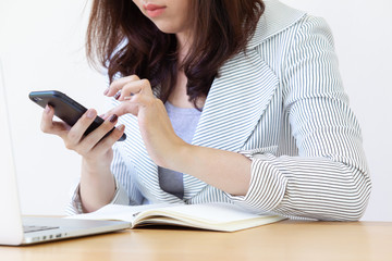 Asian business women using both of laptop and smartphone close up.