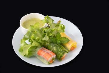Fresh vegetable noodle spring roll with sauce on plate, Salad roll, On a black background. Diet or cook concept.