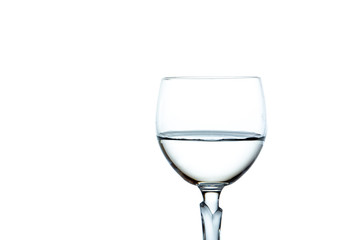 Water in a wine glass close up, isolated on white background.