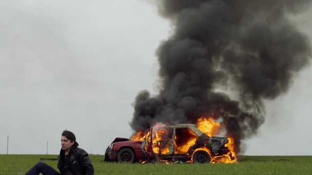 The guy runs away from the burning car, car explosion
