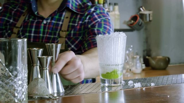 Caipirinha cocktail. The barman preparing an alcoholic drink in a bar. 4K