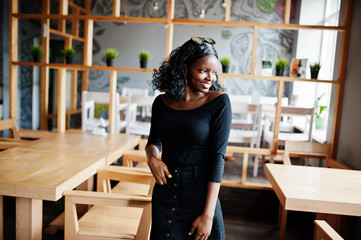 Naklejka na ściany i meble African american girl posed at wooden modern cafe.