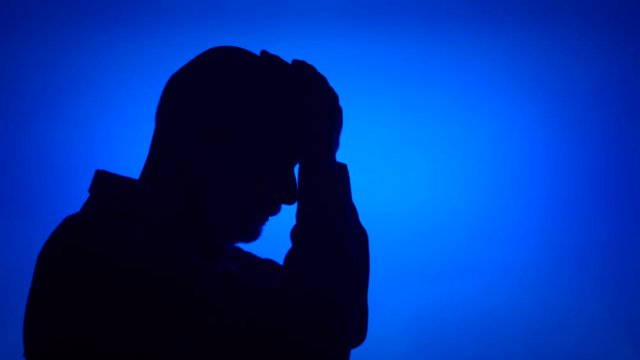 Silhouette of senior frustrated man. Sad male's face in profile in despair on blue background. Black contour shadow of sad grandfather's half-face showing strong negative emotions