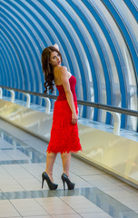Beautiful young girl in red walking around the Mall