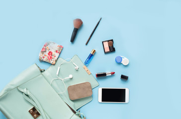 Topview of Fashionable female accessories watch glasses lipstick perfume and blue bag. Overhead of...