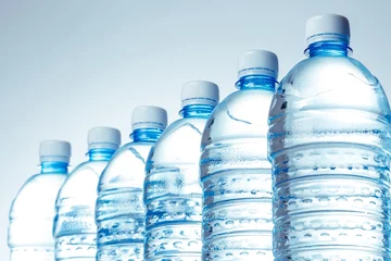 Foto op Plexiglas Six Water Bottles in a Row on the Blue Background © BillionPhotos.com