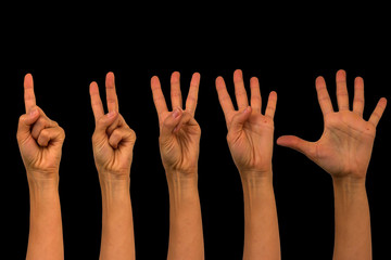 Isolated female hands on a black background. Counting on one to five fingers