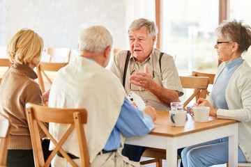 Gruppe Senioren als Freunde beim Karten spielen