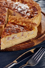 Appetizing cheese cake with sausage, ham. Snack unsweetened cake with crispy cheese crust. An unusual variant of pizza is 