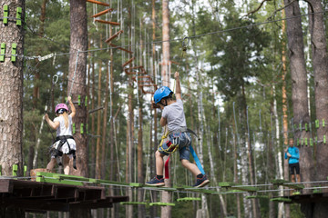 Obraz na płótnie Canvas Outdoor activities. Rope town in the woods. Climbing trees and ropes with insurance.