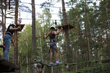 Outdoor activities. Rope town in the woods. Climbing trees and ropes with insurance.