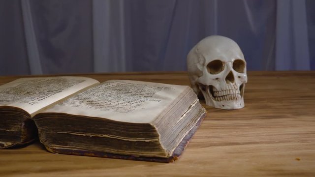 the magic rite. Ancient book and human skull. Concept for Halloween