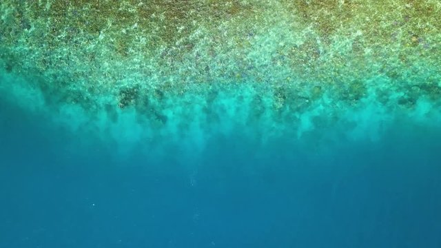 Bora Bora aerial footage from a drone of clear blue ocean coast at Bora Bora island, Tahiti, French Polynesia, South Pacific Ocean
