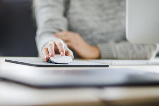 Junge Frau benutzt die Maus ihres Computers