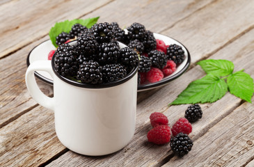 Cup of ripe blackberries and raspberries