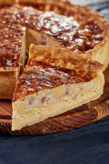 Appetizing cheese cake with sausage, ham. Snack unsweetened cake with crispy cheese crust. An unusual variant of pizza is 