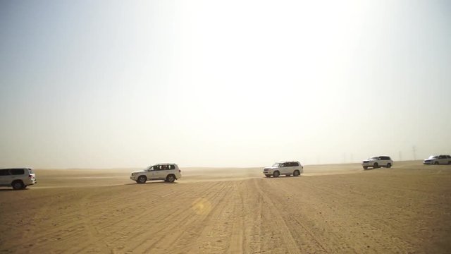 SUV Trip for tourists in the desert. Stock. Group of people driving off road car in the Vietnam desert during a safari. Troupe of friends having fun on dune sand. Concept of authentic adventure