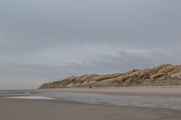 People walking down the beach in winter