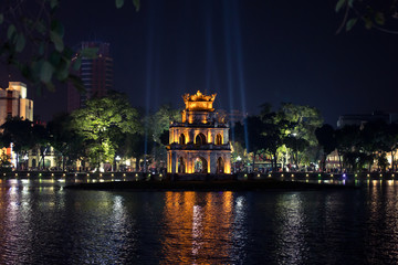 Fototapeta na wymiar The heart of old Hanoi Hoan Kiem Lake at night illuminated by lights with a bright reflection in the water