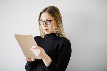 Junge Frau im Pullover spielt am Tablet Computer