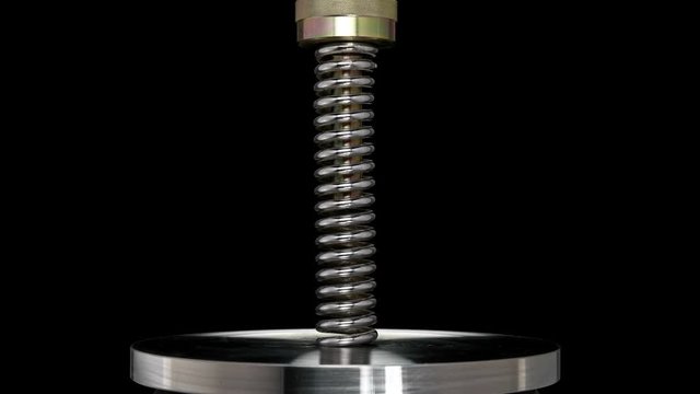 test of reliability of a spring, compression and decompression by a hydraulic press, close-up