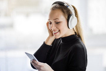 Junge Frau hört mit kabellosen Kopfhörer Musik 